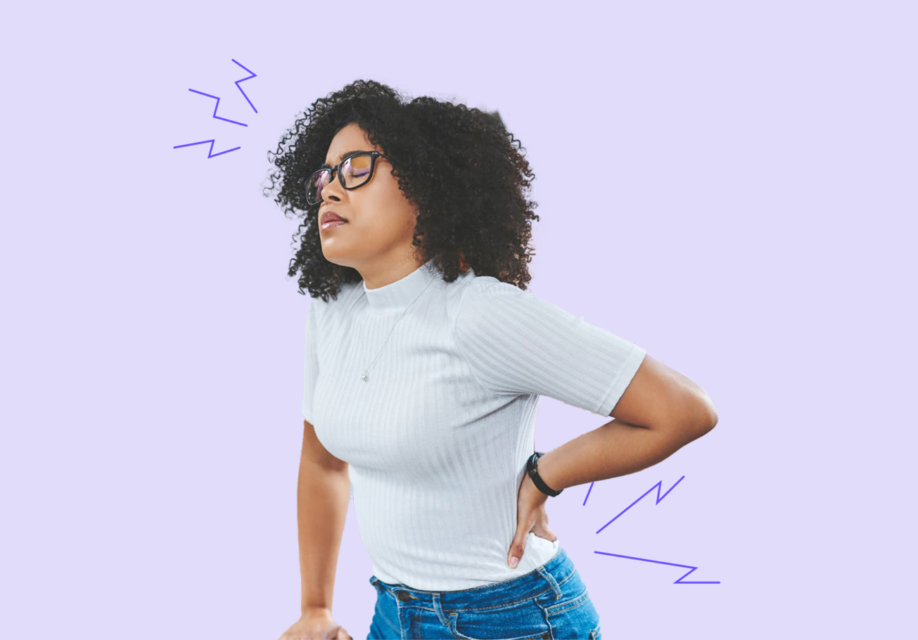 Eine Frau mit Brille hat akute Rückenschmerzen und hält sich mit schmerzverzerrtem Gesicht den unteren Rücken.